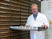 Apotheker Franz Kirchner vor den Arznei-Regalen